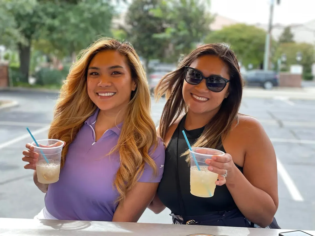 Two guests smiling with drinks during a Pensacola Pedal Trolley outing